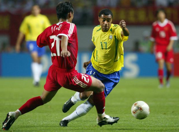 Brazil's Denilson (R) vies for the ball with China's Xu Yunlong (L), 08 June 2002 at the Jeju World Cup Stadium in Seogwipo, during first round Group C action between Brazil and China in the 2002 FIFA World Cup Korea/Japan. AFP PHOTO/ANTONIO SCORZA (Photo by ANTONIO SCORZA / AFP)