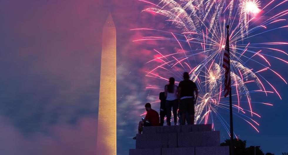 El público se sienta en la cima de un pilar en el Memorial de la Segunda Guerra Mundial mientras los fuegos artificiales estallan en Washington, DC durante las celebraciones por el Día de la Independencia de Estados Unidos. (Foto de ROBERTO SCHMIDT / AFP).