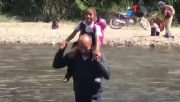 En la provincia de Oxapampa, docentes ayudan a escolares a cruzan el río Chorobamba para que no pierdan clases. (Captura: TV Perú)